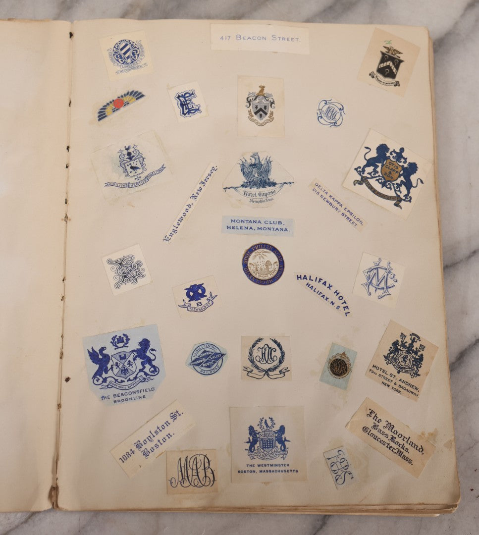 Lot 294 - Antique Scrapbook With Clipped Logos, Seals, And Institutional Names From Colleges, Hotels, Clubs, Banks, Government Offices, And More, Arranged By Color Throughout 20+ Pages, Marbled Cover Boards