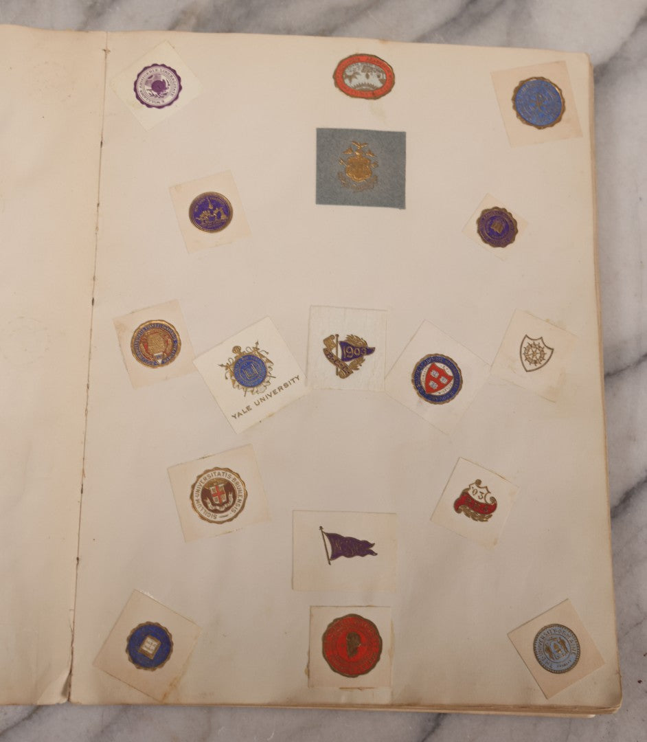 Lot 294 - Antique Scrapbook With Clipped Logos, Seals, And Institutional Names From Colleges, Hotels, Clubs, Banks, Government Offices, And More, Arranged By Color Throughout 20+ Pages, Marbled Cover Boards