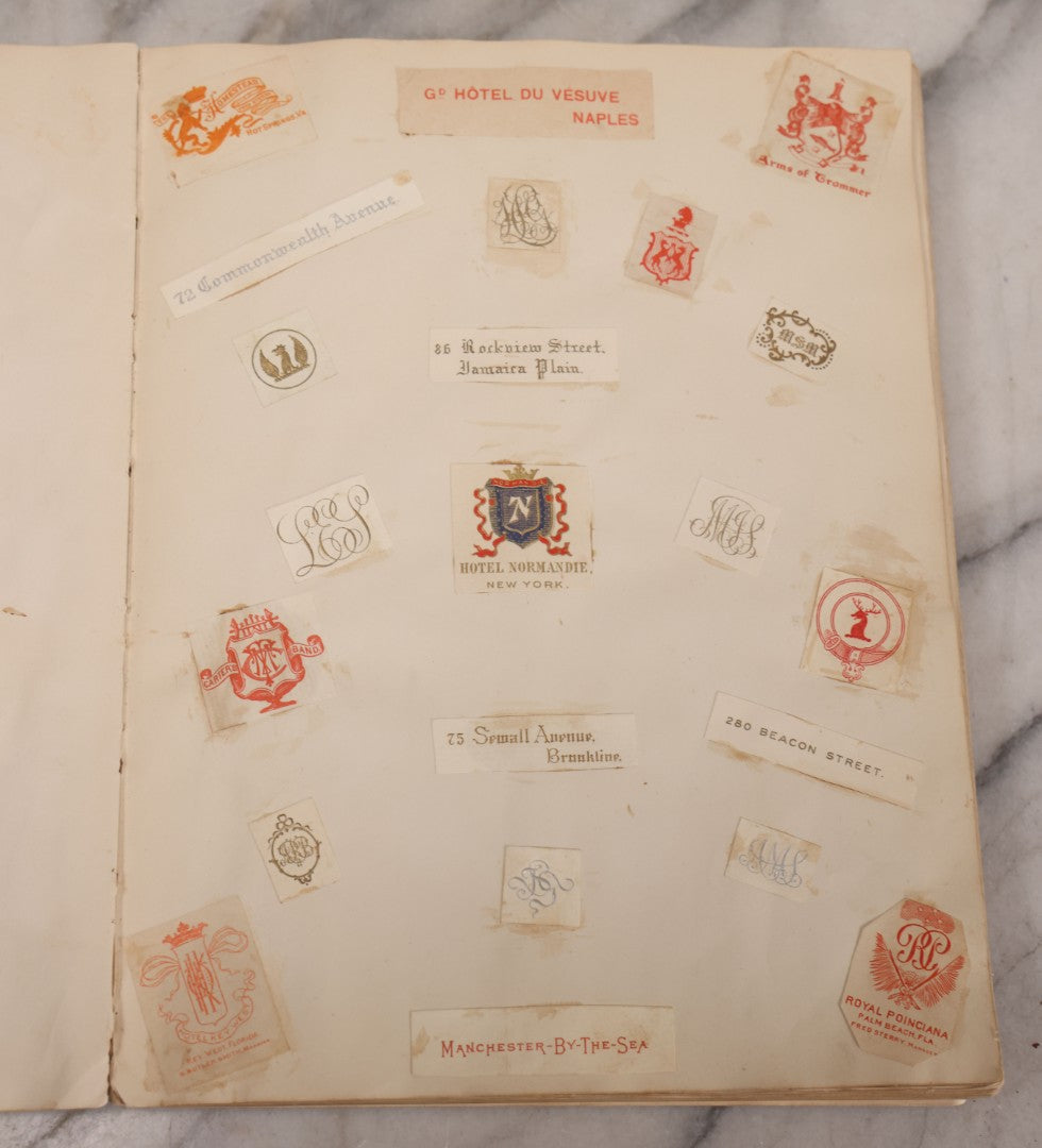 Lot 294 - Antique Scrapbook With Clipped Logos, Seals, And Institutional Names From Colleges, Hotels, Clubs, Banks, Government Offices, And More, Arranged By Color Throughout 20+ Pages, Marbled Cover Boards