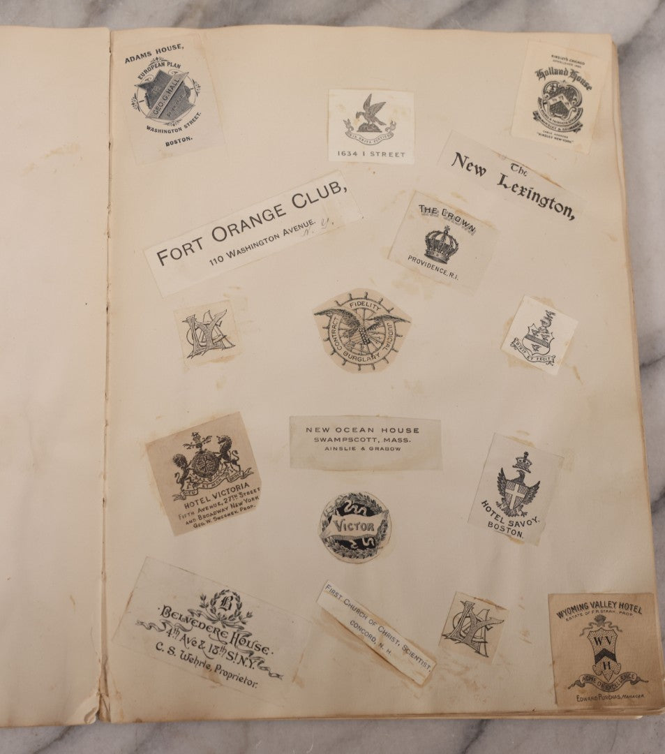 Lot 294 - Antique Scrapbook With Clipped Logos, Seals, And Institutional Names From Colleges, Hotels, Clubs, Banks, Government Offices, And More, Arranged By Color Throughout 20+ Pages, Marbled Cover Boards