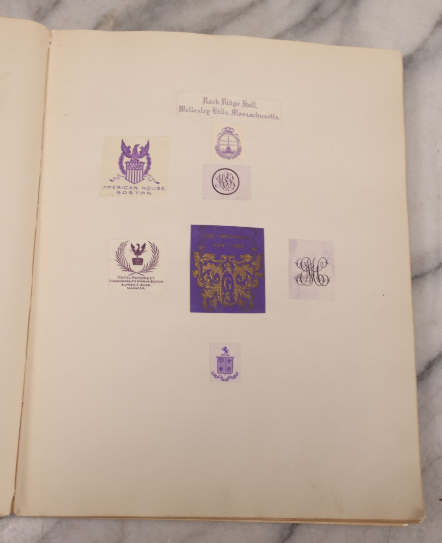 Lot 294 - Antique Scrapbook With Clipped Logos, Seals, And Institutional Names From Colleges, Hotels, Clubs, Banks, Government Offices, And More, Arranged By Color Throughout 20+ Pages, Marbled Cover Boards