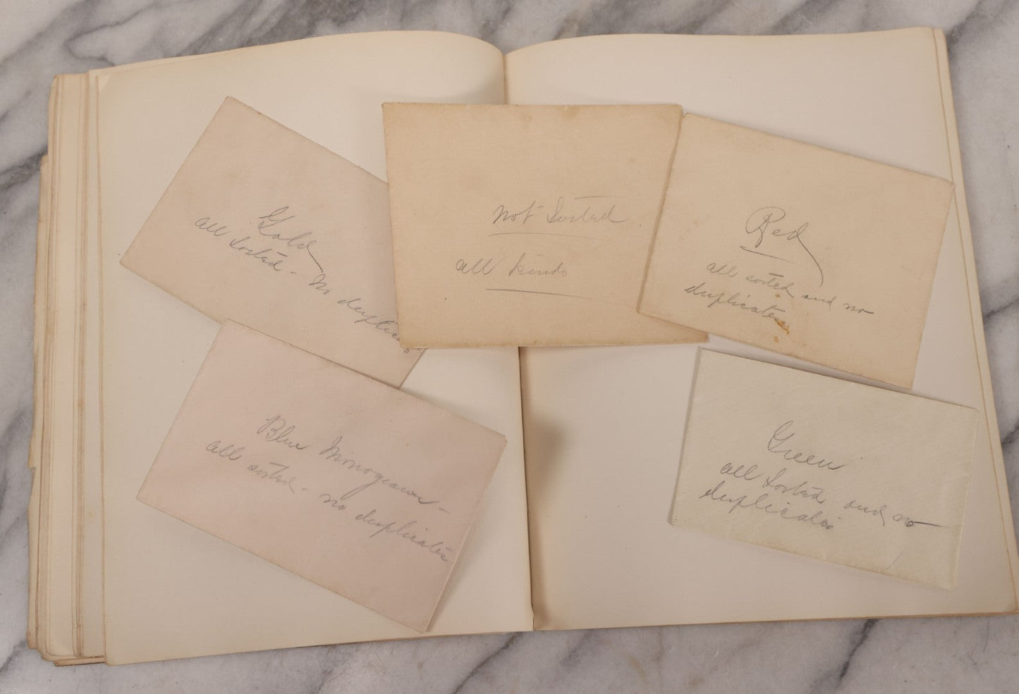 Lot 294 - Antique Scrapbook With Clipped Logos, Seals, And Institutional Names From Colleges, Hotels, Clubs, Banks, Government Offices, And More, Arranged By Color Throughout 20+ Pages, Marbled Cover Boards