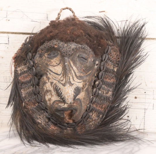 Lot 018 - Vintage African-Style Mask With Woven Fiber, Cowrie Shell Decoration, Animal Skull Element, And Hair Fringe, 11" x 15"