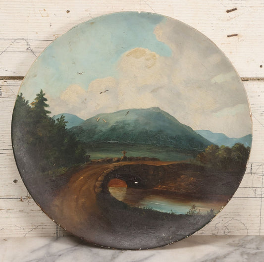 Lot 044 - Antique Folk Art Hand Painted Papier Mache Charger With Stone Bridge, Mountain Lake Landscape, And Cloudy Sky, Circa 1880, 12-1/8" Diameter