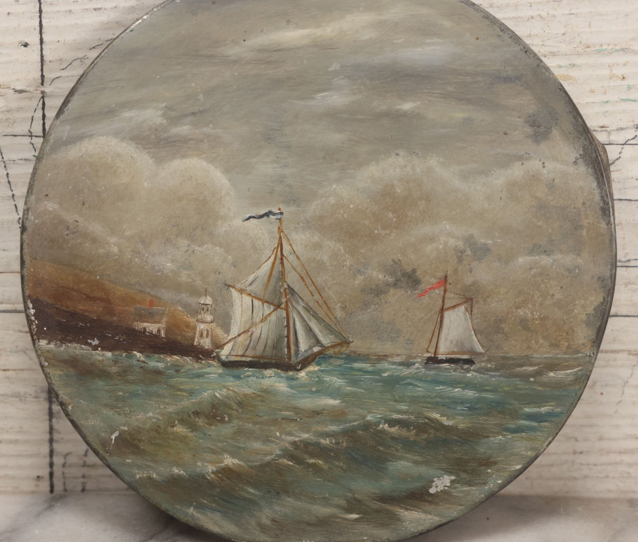 Lot 047 - Antique Hand-Painted Maritime Seascape On Tin Lid With Sailboats And Lighthouse, Unsigned, 6-1/4" Diameter
