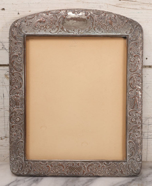Lot 054 - Antique French Silvered Bronze Picture Frame With Repoussé Floral Scrollwork And Figural Scenes, With Glass, Circa Early 20th Century, 10-3/4" x 13-1/2"