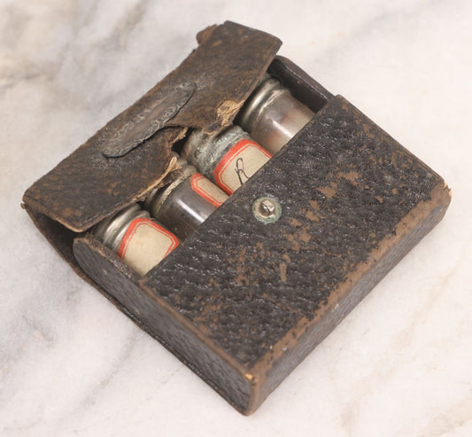 Lot 067 - Antique Pocket Apothecary / Homeopathic Vial Set With Four Glass Vials In Leatherette Case, Metal Screw Caps, Handwritten Labels