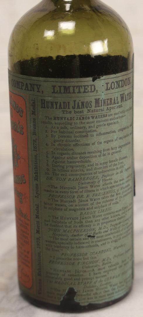 Lot 069 - Antique Hunyadi János Budai Mineral Spring Water Bottle With Paper Label, The Apollinaris Company, Andreas Saxlehner, Budapest, Hungary, 9-1/4" H