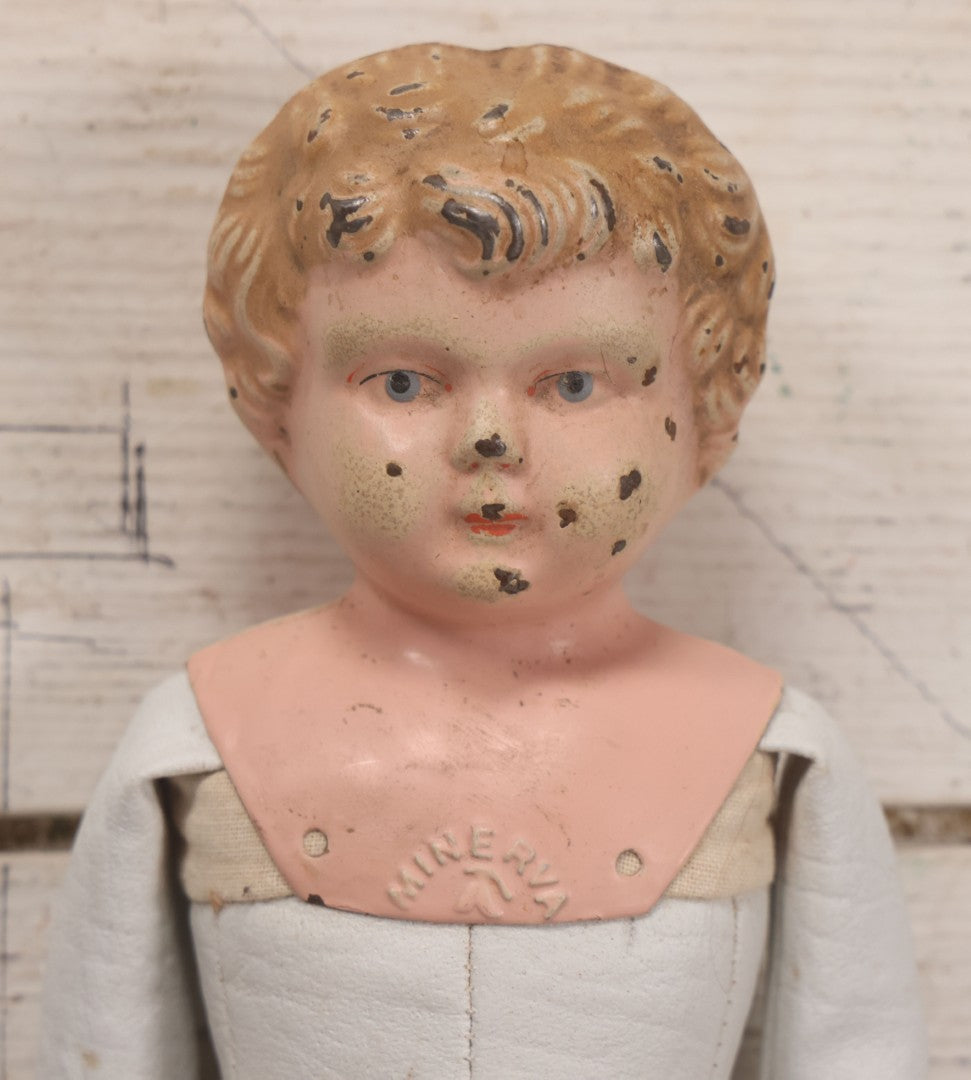 Lot 084 - Antique German Minerva Metal Head Doll With Molded Blonde Hair And Painted Features, Cloth And Leather Body, Circa 1900s-1920s 12" H
