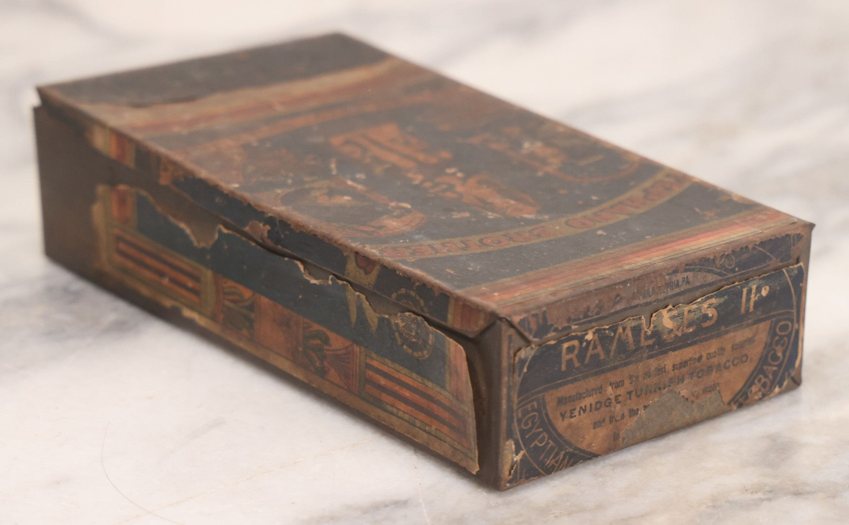 Lot 106 - Antique Stephano Brothers Paper Covered Egyptian Cigarette Tin For Ramses II Cigarettes, Manufactured From Yenidj Turkish Tobacco, Philadelphia, Pennsylvania