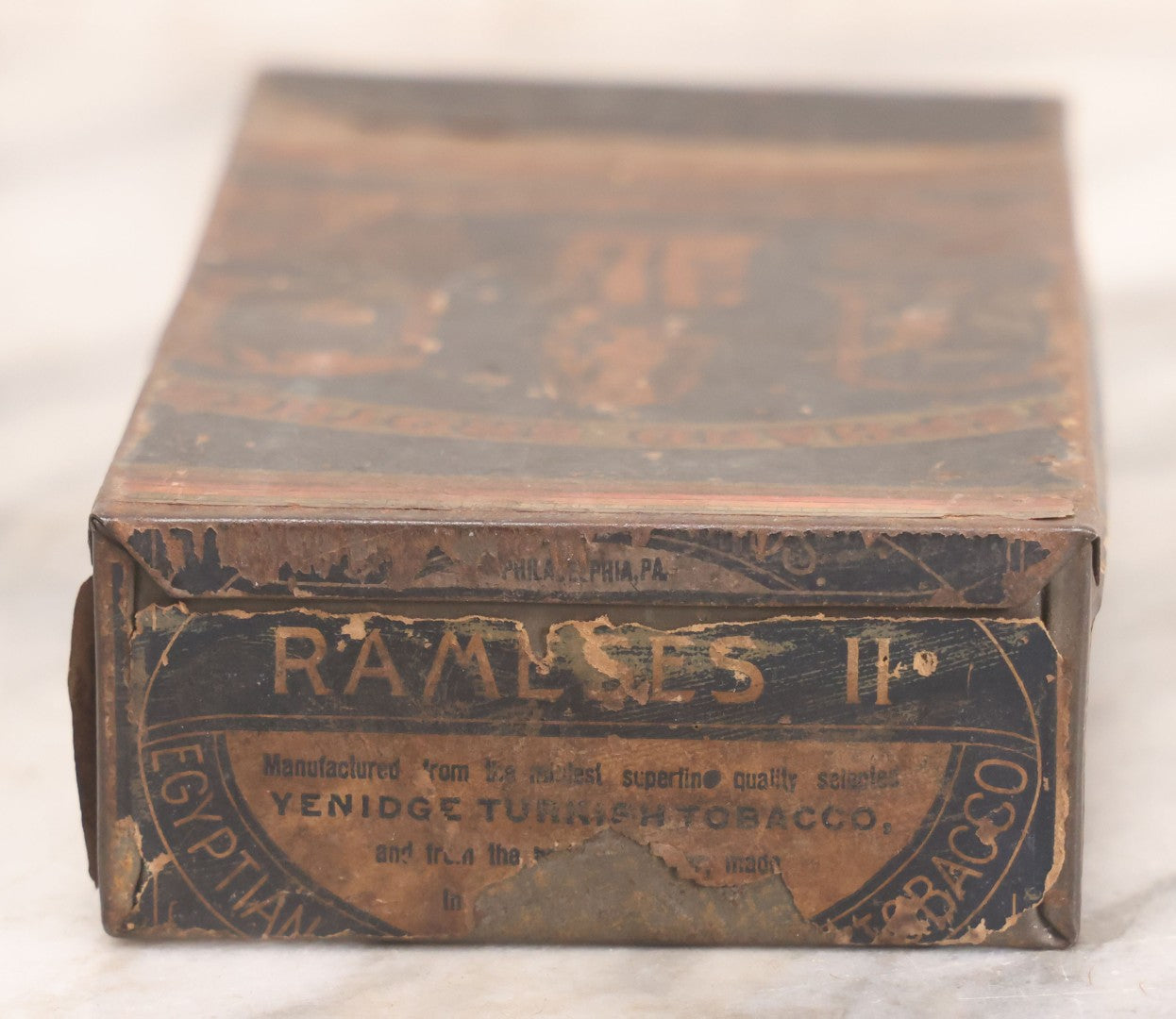 Lot 106 - Antique Stephano Brothers Paper Covered Egyptian Cigarette Tin For Ramses II Cigarettes, Manufactured From Yenidj Turkish Tobacco, Philadelphia, Pennsylvania