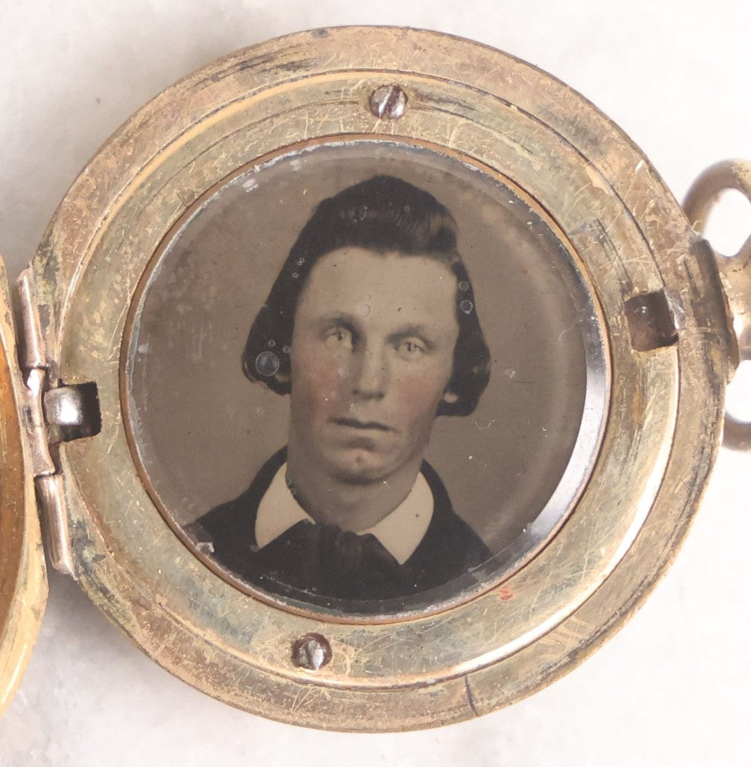 Lot 141 - Antique Gold Toned Locket With Tintype Photographs Of A Young Woman And Man Under Beveled Glass Circles