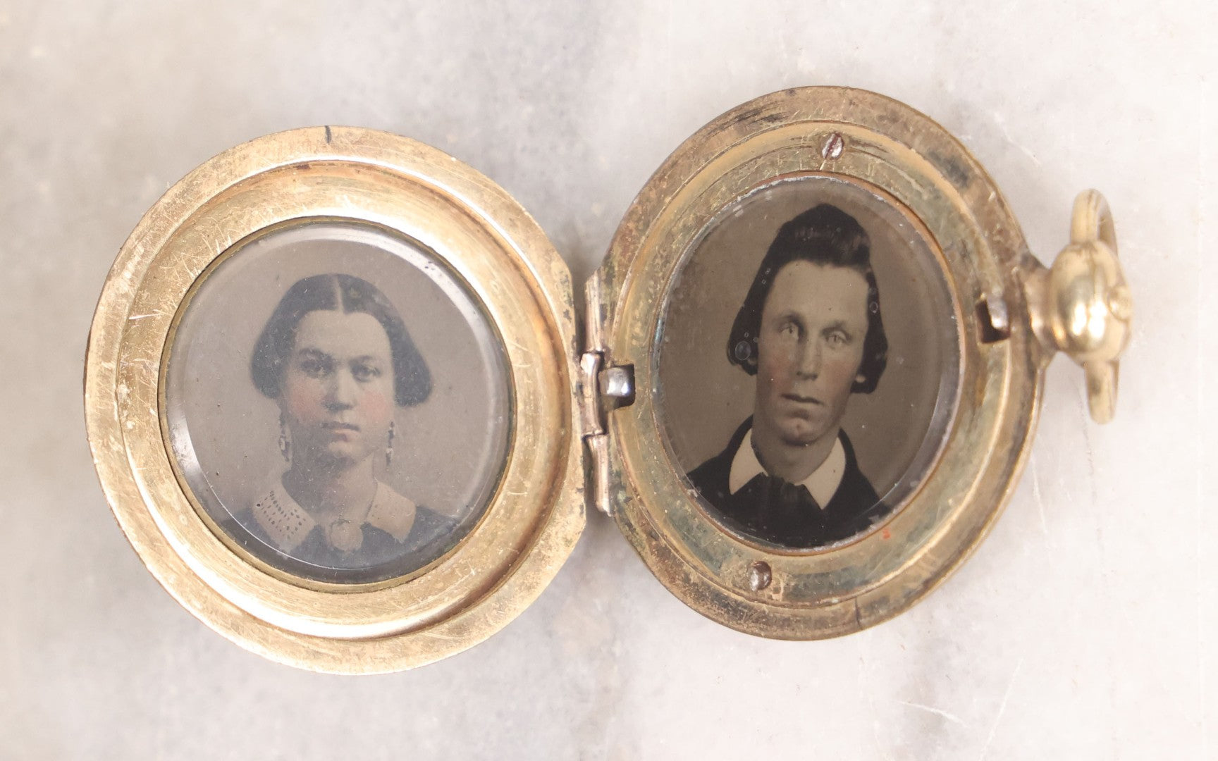 Lot 141 - Antique Gold Toned Locket With Tintype Photographs Of A Young Woman And Man Under Beveled Glass Circles
