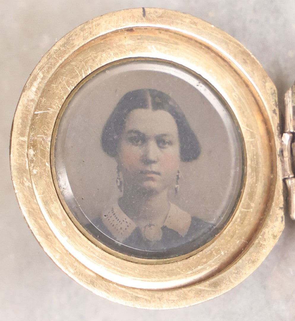 Lot 141 - Antique Gold Toned Locket With Tintype Photographs Of A Young Woman And Man Under Beveled Glass Circles