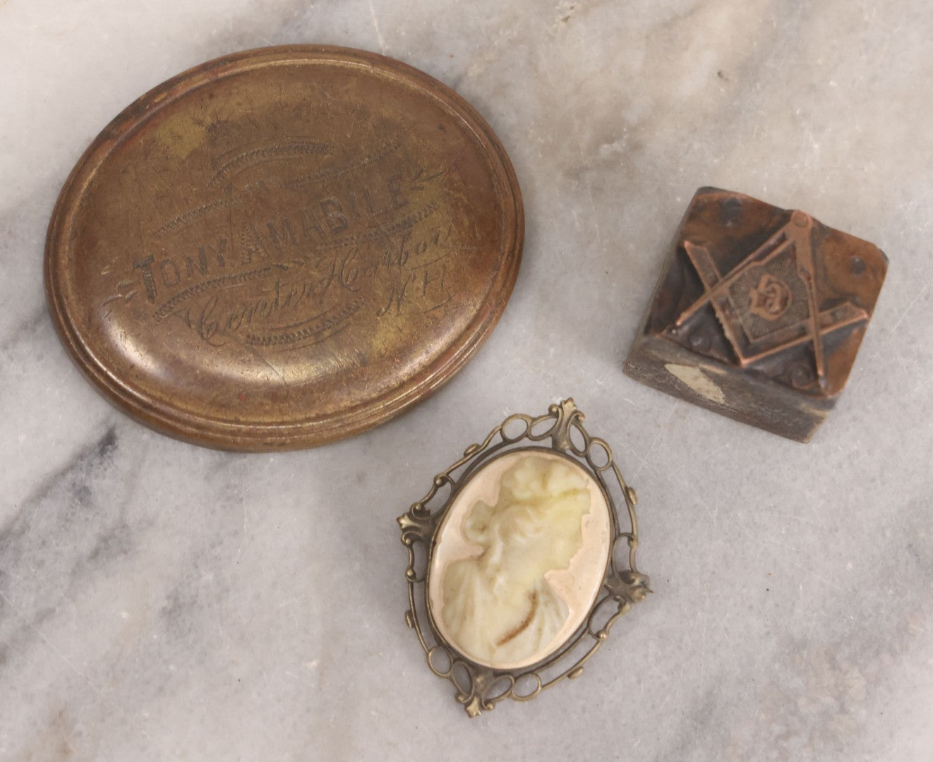 Lot 161 - Trio Of Miscellaneous Vintage Smalls Including Tony Amabile, Center Harbor, New Hampshire Metal Badge, Masonic Printing Block, Vintage Costume Jewelry Cameo Brooch