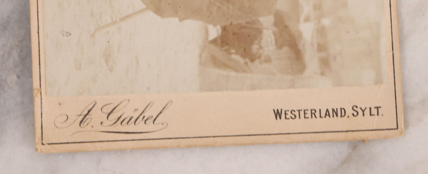 Lot 179 - Antique Board-Mounted Photograph Of Three Mustachioed Men Posed On Beach In Suits With Capes And Walking Sticks Before Striped Beach Windbreak, Westerland, Sylt, Photographed By A. Gabel