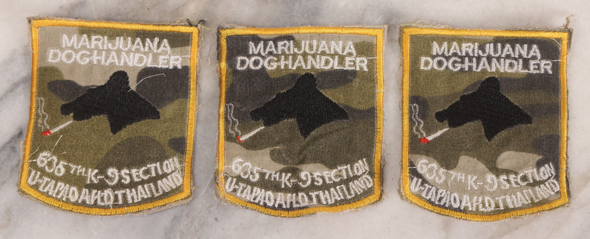 Lot 205 - Grouping Of Six Vintage Vietnam Era Marijuana Doghandler United States Air Force 635th K-9 Section, Thailand Embroidered Patches With Silhouette Of Dog Smoking Joint