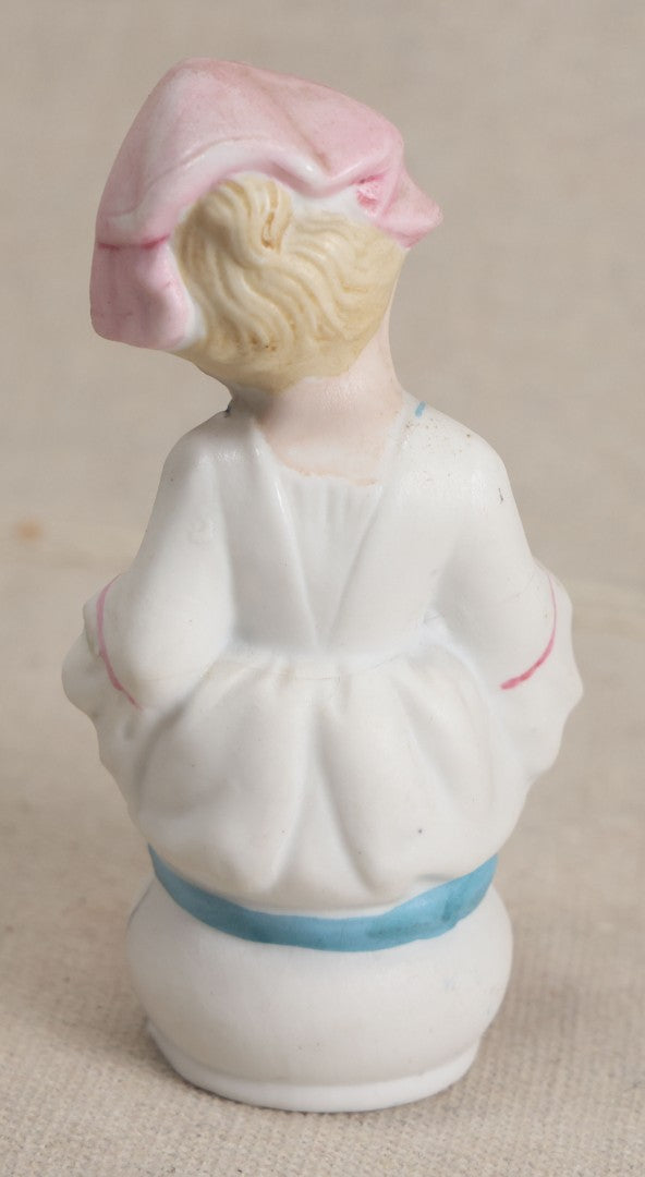 Lot 180 - Antique Bisque Figure of a Child With Pink Hat Seated on a Chamber Pot, Likely German, Note Severe Crack Across Midsection