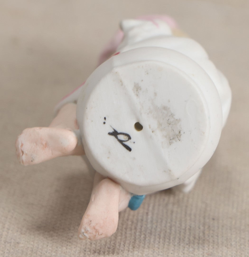 Lot 180 - Antique Bisque Figure of a Child With Pink Hat Seated on a Chamber Pot, Likely German, Note Severe Crack Across Midsection