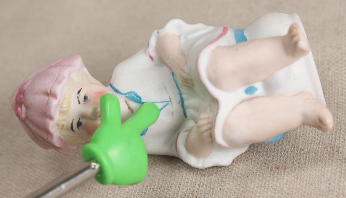 Lot 180 - Antique Bisque Figure of a Child With Pink Hat Seated on a Chamber Pot, Likely German, Note Severe Crack Across Midsection