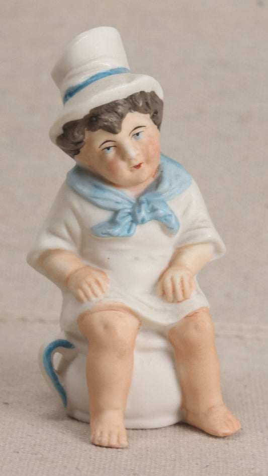 Lot 181 - Antique Bisque Figure of a Child With White Hat Seated on a Chamber Pot, Likely German