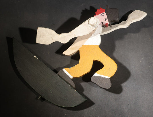 Lot 039 - Vintage Folk Art Painted Wood Clown Whirligig, Red Hair, Black Hat, Yellow Trousers, Paddle Arms, On Dark Green Crescent Base
