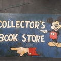 Lot 042 - Vintage Hand-Painted "Collector's Book Store" Sign With Mickey Mouse And Pointing Hand On Hardboard Panel, 28-3/4" x 16-3/4"