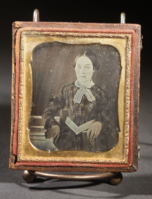 Lot 113 - Antique 1/6th Plate Daguerreotype Photograph, Half Split Leatherette Union Case With Embossed Floral Bouquet Design, Portrait Of A Middle-Aged Woman In Plaid Dress With Lace Collar, Holding Books