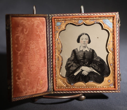 Lot 117 - Antique 1/6th Plate Ruby Ambrotype Photograph, Full Intact Leatherette Union Case, Young Woman In Dark Dress With Crossed Hands, Embossed Thistle And Floral Case Design