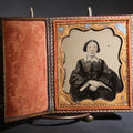 Lot 117 - Antique 1/6th Plate Ruby Ambrotype Photograph, Full Intact Leatherette Union Case, Young Woman In Dark Dress With Crossed Hands, Embossed Thistle And Floral Case Design