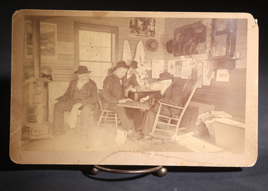 Lot 130 - Antique Boudoir-Size Cabinet Card Photograph Of Three Men Playing Checkers In A Store Interior With Pot-Belly Stove, Calendars, And Rocking Chair, Pencil-Inscribed "Uncle Ed"
