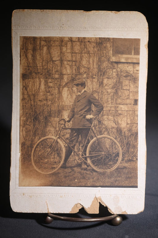 Lot 133 - Antique Cabinet Card Photograph Of A Young Man In A Suit And Cap Posed With A Bicycle Before A Vine-Covered Stone Wall