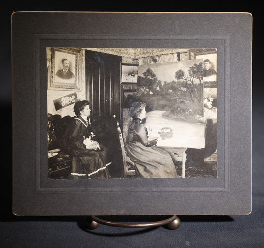 Lot 136 - Antique Board-Mounted Occupational Photograph Of A Woman Painting A Landscape At An Easel In A Parlor, Second Woman With Cat In Lap, Pencil-Inscribed "Lorna Penfold And Her Momma"