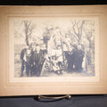 Lot 137 - Antique Board-Mounted Photograph Of A Group Of Children With American Flags Posed Around A Wooden Structure Outdoors