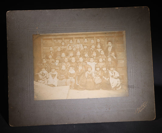 Lot 139 - Antique Board-Mounted Photograph Of Japanese Children In Kimono With Their Teacher, One Child Picking His Nose, Photographed By N. Ohashi