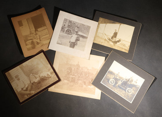 Lot 150 - Grouping Of Six Antique Board-Mounted Photographs Of Men In Social And Leisure Settings, Including Early Automobile Group, City Street Scene With Jackson Sign, Men In Hammock On Porch, And Outdoor Picnic Party