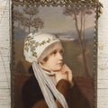 Lot 012 - Antique Painted Porcelain Tile Of Young Woman in White Head Scarf Posed Before Landscape with Clasped Hands, In Brass Frame With Crest, Note Large Crack, 4-7/8" x 9-1/8"