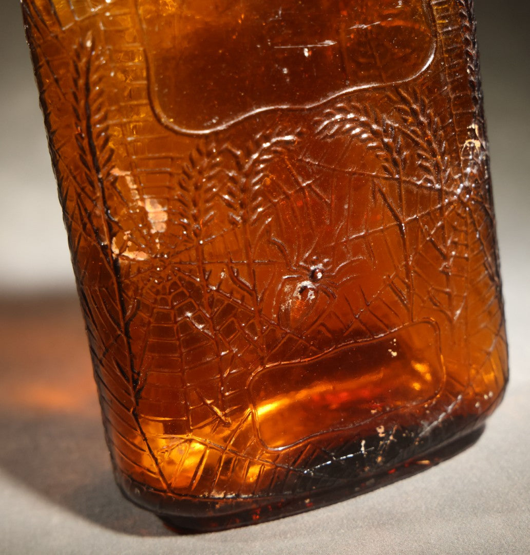 Vintage Embossed Amber Glass Whiskey Bottle with Spider Web, Spider, and Wheat Motifs, Marked "Non Refillable" and "Pat. Pending"