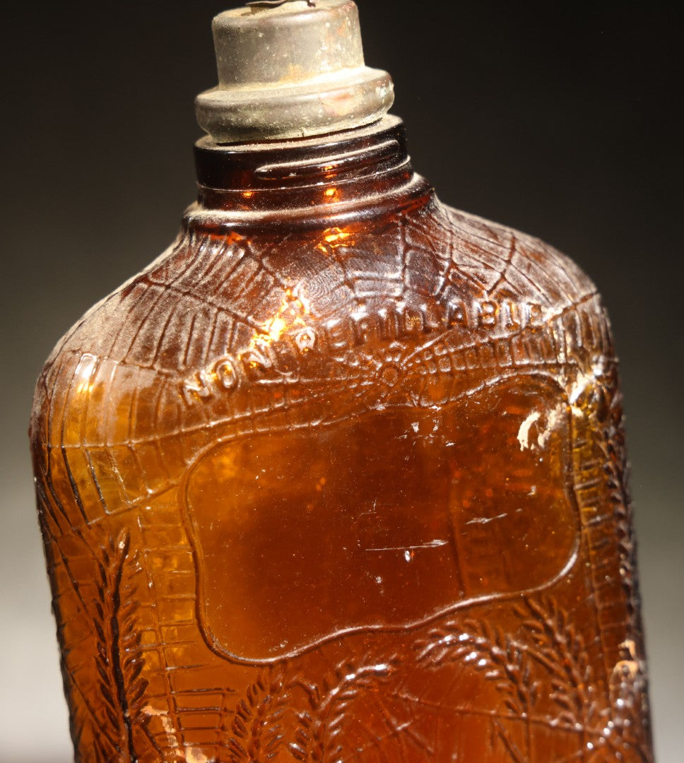 Vintage Embossed Amber Glass Whiskey Bottle with Spider Web, Spider, and Wheat Motifs, Marked "Non Refillable" and "Pat. Pending"