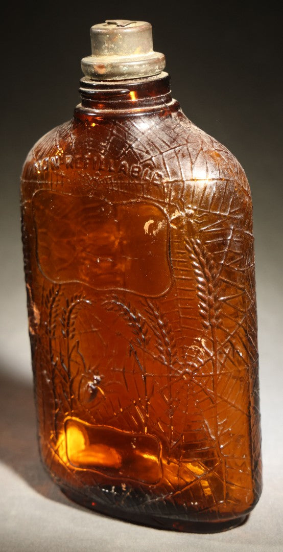 Vintage Embossed Amber Glass Whiskey Bottle with Spider Web, Spider, and Wheat Motifs, Marked "Non Refillable" and "Pat. Pending"