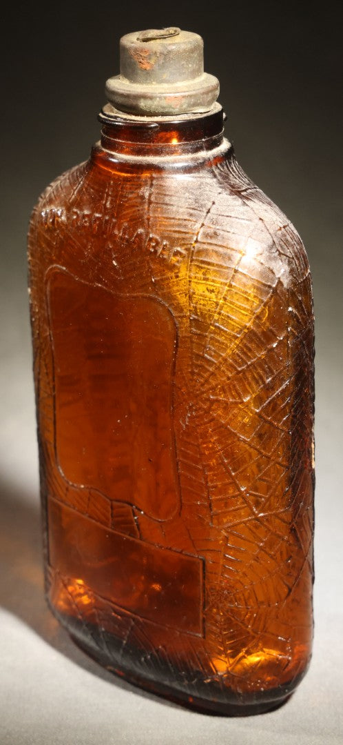 Vintage Embossed Amber Glass Whiskey Bottle with Spider Web, Spider, and Wheat Motifs, Marked "Non Refillable" and "Pat. Pending"
