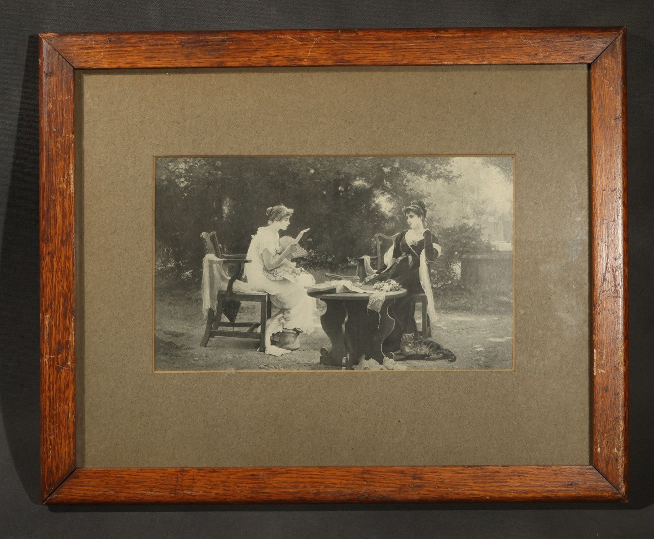 Antique Framed Print After "Her First Love Letter" by Marcus Stone (English, 1840-1921), Two Young Women Seated at a Garden Table with a Cat