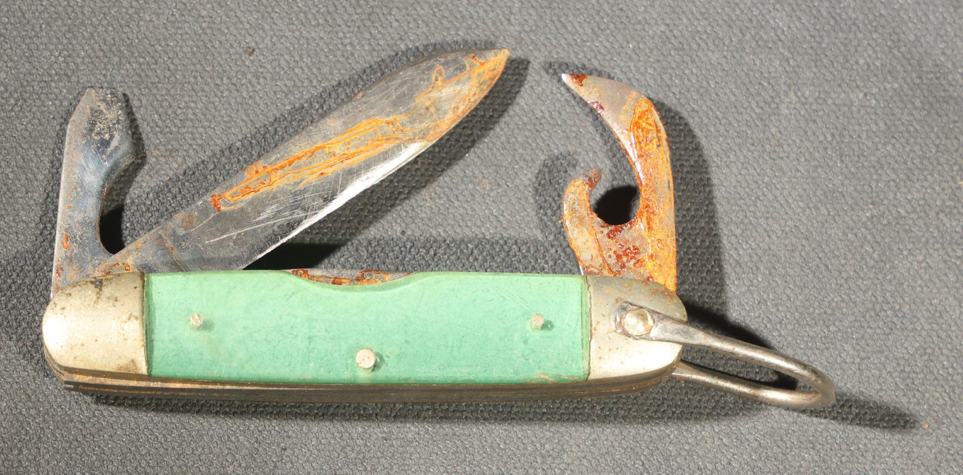 Grouping of Seven Vintage Folding Pocket Knives Including Multi-Tool Camp Knives, Stockman, and Trapper Styles with Bone, Jigged, and Composite Handles