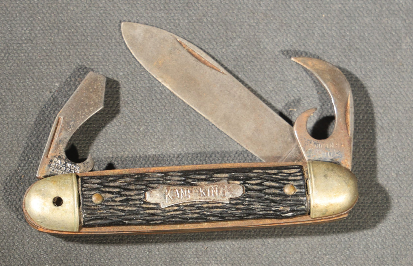 Grouping of Seven Vintage Folding Pocket Knives Including Multi-Tool Camp Knives, Stockman, and Trapper Styles with Bone, Jigged, and Composite Handles