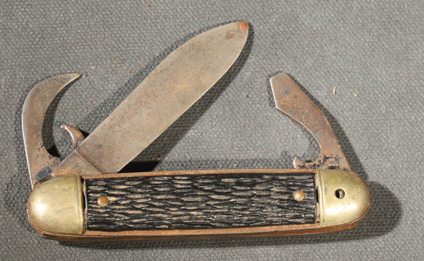 Grouping of Seven Vintage Folding Pocket Knives Including Multi-Tool Camp Knives, Stockman, and Trapper Styles with Bone, Jigged, and Composite Handles