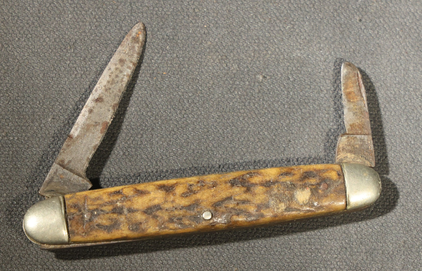 Grouping of Seven Vintage Folding Pocket Knives Including Multi-Tool Camp Knives, Stockman, and Trapper Styles with Bone, Jigged, and Composite Handles