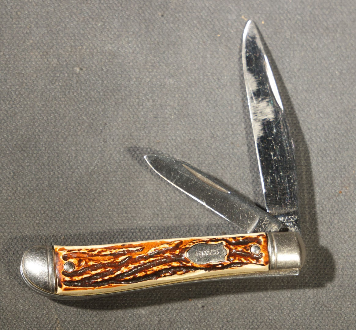 Grouping of Seven Vintage Folding Pocket Knives Including Multi-Tool Camp Knives, Stockman, and Trapper Styles with Bone, Jigged, and Composite Handles
