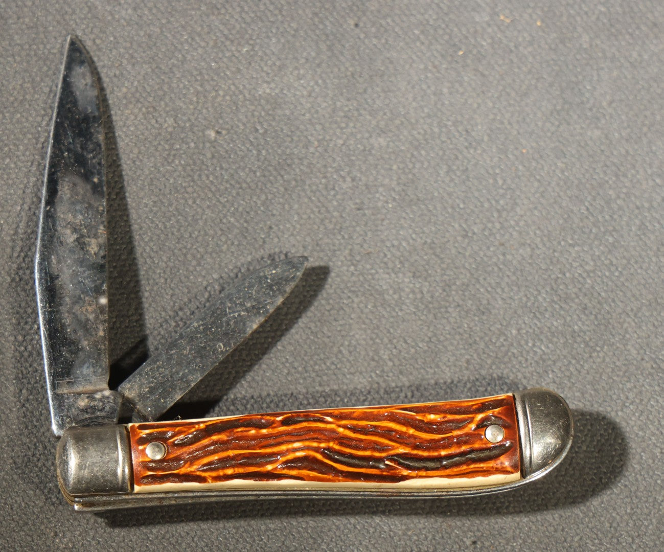 Grouping of Seven Vintage Folding Pocket Knives Including Multi-Tool Camp Knives, Stockman, and Trapper Styles with Bone, Jigged, and Composite Handles