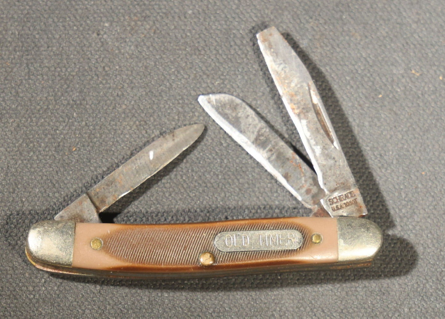 Grouping of Seven Vintage Folding Pocket Knives Including Multi-Tool Camp Knives, Stockman, and Trapper Styles with Bone, Jigged, and Composite Handles