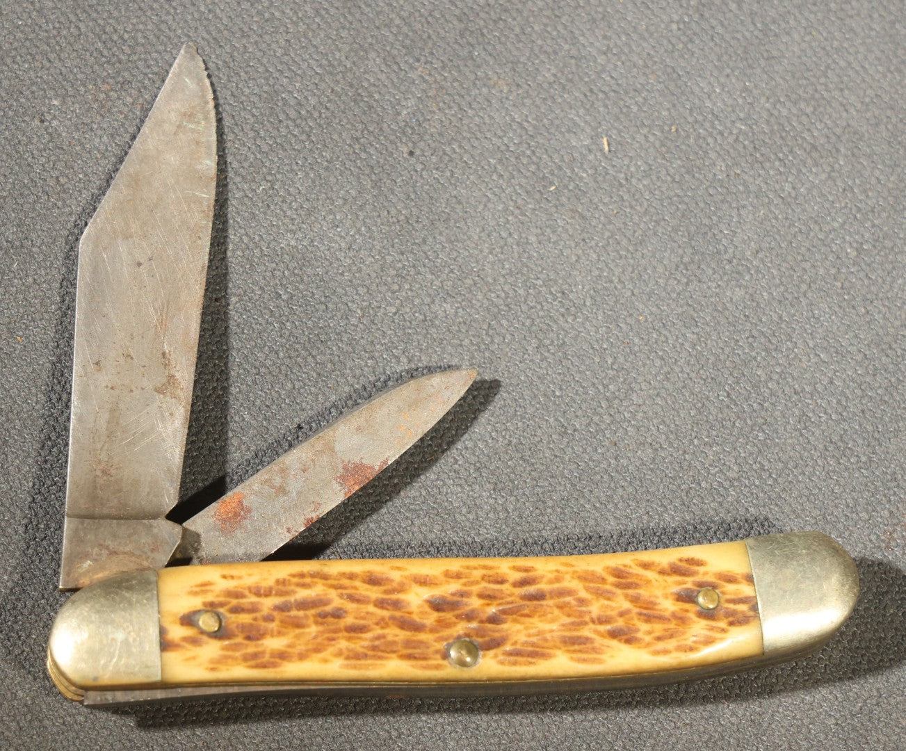 Grouping of Seven Vintage Folding Pocket Knives Including Multi-Tool Camp Knives, Stockman, and Trapper Styles with Bone, Jigged, and Composite Handles